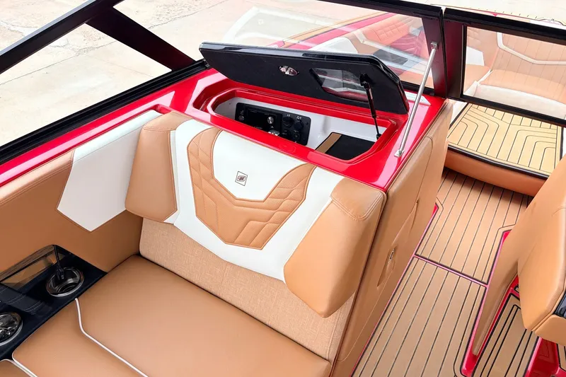 Slide: The Image of 2022 Nautique Super Air Nautique G25 interior with tan and white seating, red accents. - 20