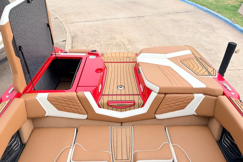 Slide: The Image of 2022 Nautique Super Air Nautique G25 interior with tan and white upholstery, open storage compartment. - 46