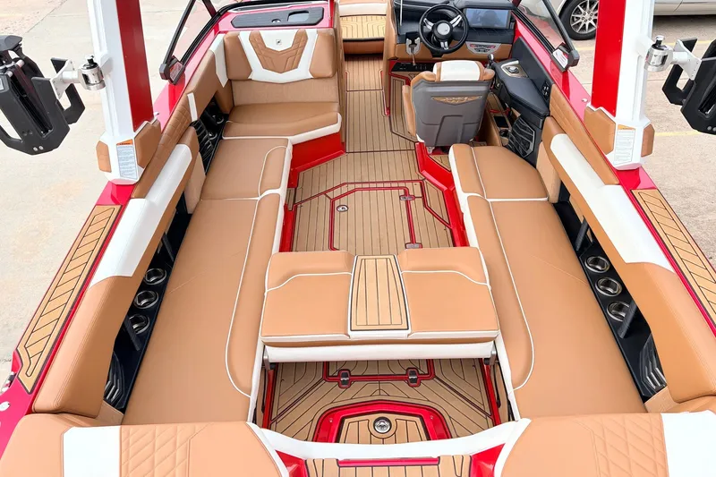 Slide: The Image of 2022 Nautique Super Air Nautique G25 interior with tan seating and red accents. - 30
