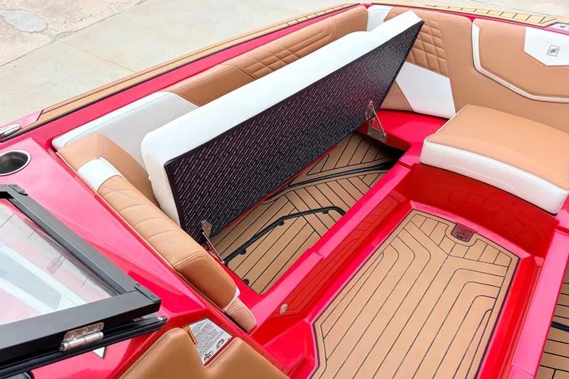 Slide: The Image of 2022 Nautique Super Air Nautique G25 interior with red and tan seating and storage. - 13
