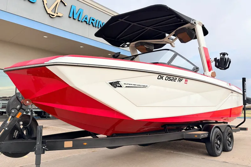 Slide: The Image of 2022 Nautique Super Air Nautique G25 boat in red and white on trailer. - 2