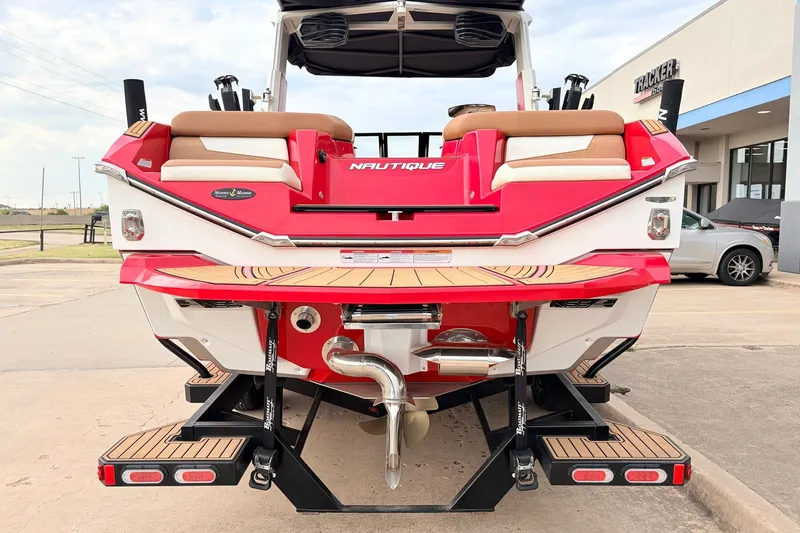 Slide: The Image of 2022 Nautique Super Air Nautique G25 boat, red and white, rear view at dealership. - 6