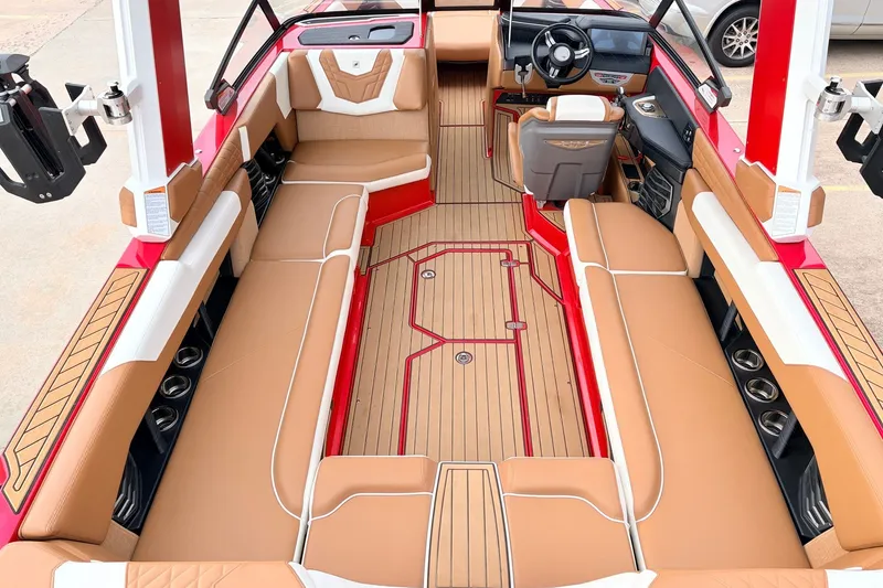 Slide: The Image of 2022 Nautique Super Air Nautique G25 interior with tan seating and red accents. - 10