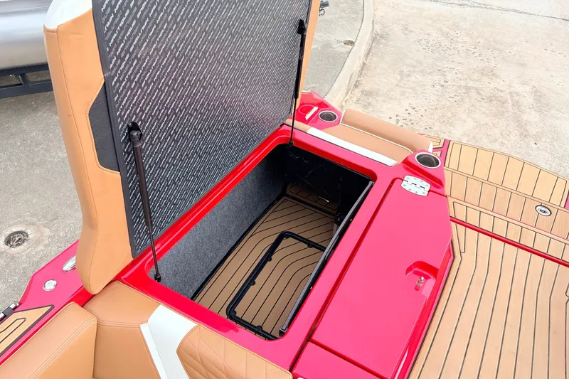 Slide: The Image of 2022 Nautique Super Air Nautique G25 open storage compartment with red and tan interior. - 47
