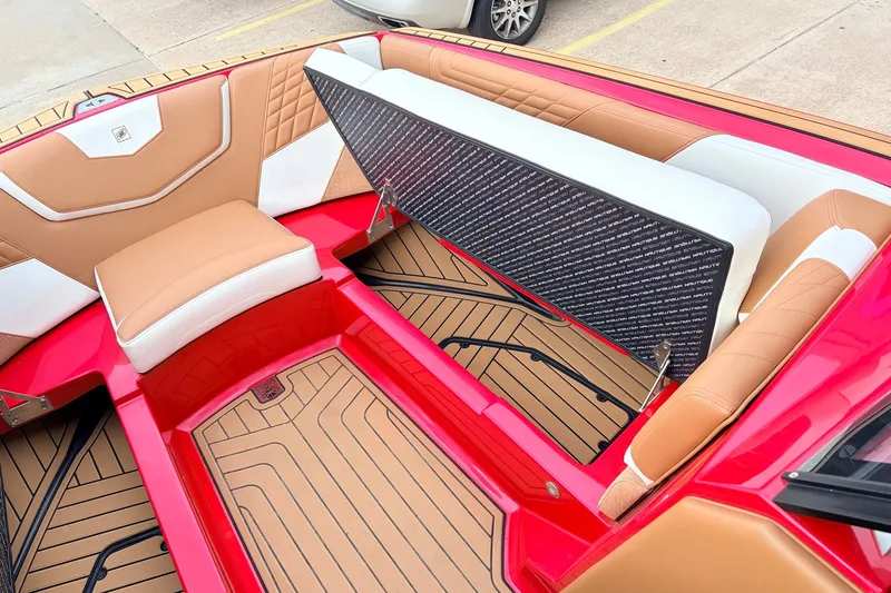 Slide: The Image of 2022 Nautique Super Air Nautique G25 interior with tan and white seating, red accents. - 14