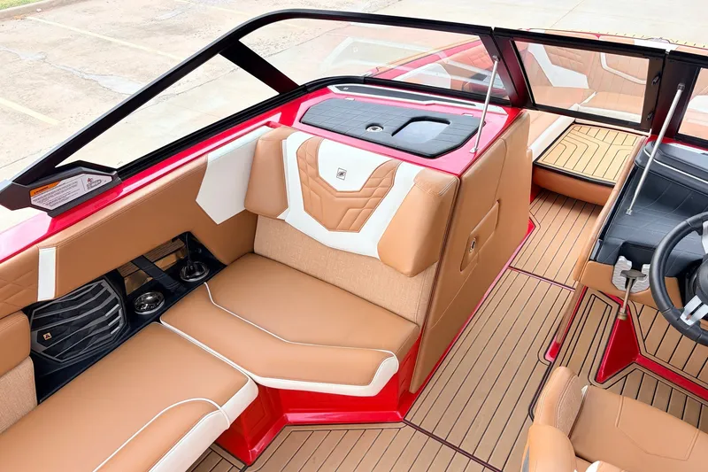Slide: The Image of 2022 Nautique Super Air Nautique G25 interior with tan and white seating, red accents, and sleek design. - 18