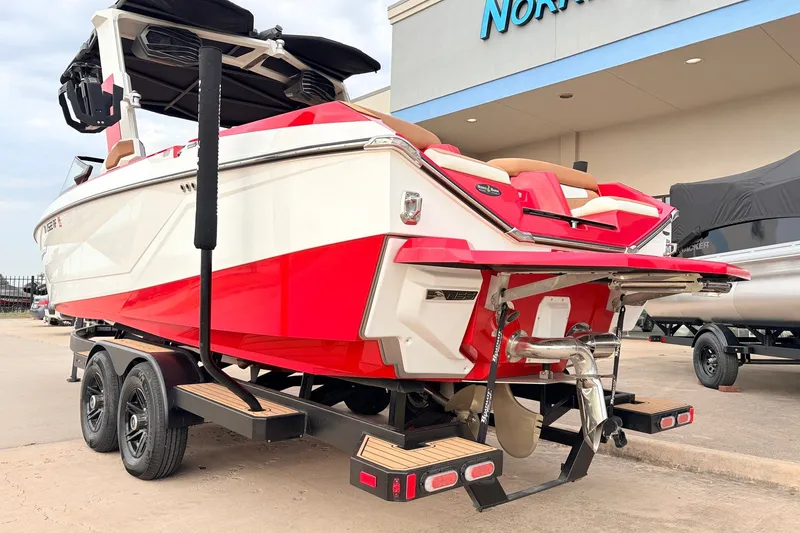 Slide: The Image of 2022 Nautique Super Air Nautique G25 boat, red and white, on trailer outside dealership. - 7
