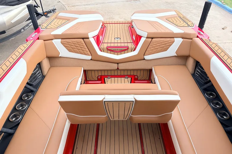 Slide: The Image of 2022 Nautique Super Air Nautique G25 interior with tan and white seating, red accents. - 29