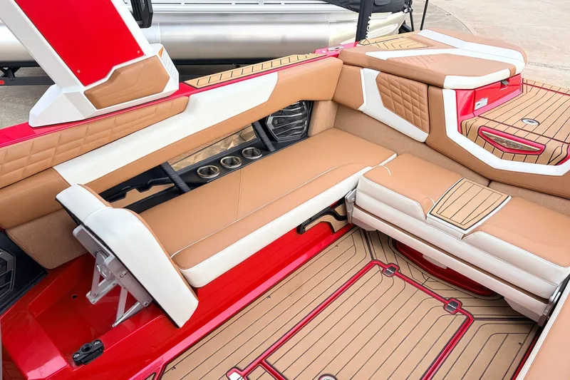 Slide: The Image of Luxurious interior of 2022 Nautique Super Air Nautique G25 boat with tan and red seating. - 35