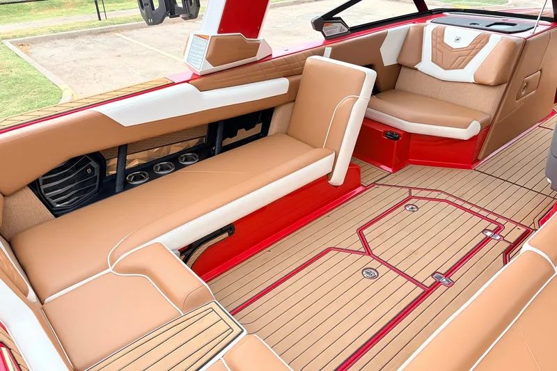 Slide: The Image of 2022 Nautique Super Air Nautique G25 interior with tan and red seating, sleek design. - 25