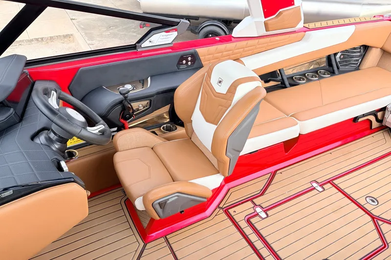 Slide: The Image of 2022 Nautique Super Air Nautique G25 interior with tan and red seating, sleek design. - 38