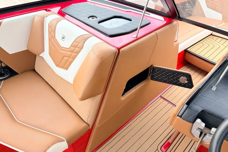Slide: The Image of 2022 Nautique Super Air Nautique G25 interior with tan and white seating, red accents. - 19