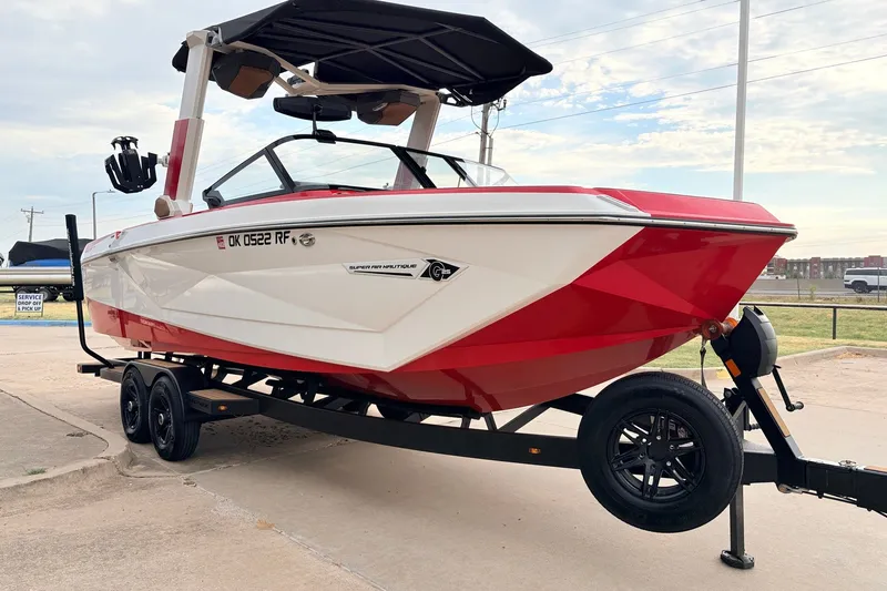Slide: The Image of 2022 Nautique Super Air Nautique G25 boat on trailer, red and white design. - 3