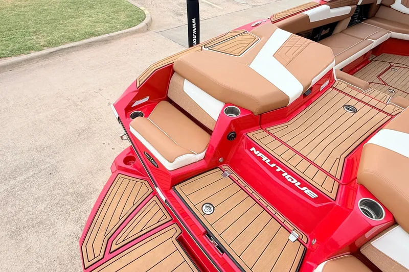 Slide: The Image of 2022 Nautique Super Air Nautique G25 boat interior with red and tan seating. - 54