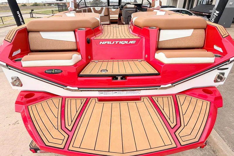 Slide: The Image of 2022 Nautique Super Air Nautique G25 boat with red and tan seating, teak deck. - 58