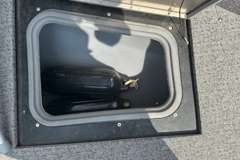 Slide: The Image of Storage compartment on a 2021 Bass Tracker Pro 16 boat with black fenders inside. - 17