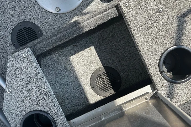 Slide: The Image of Interior of a 2021 Bass Tracker Pro 16 boat, featuring carpeted flooring and cup holders. - 30