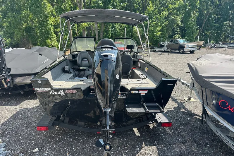 Slide: The Image of 2021 Bass Tracker Pro 16 boat with outboard motor, parked outdoors. - 38