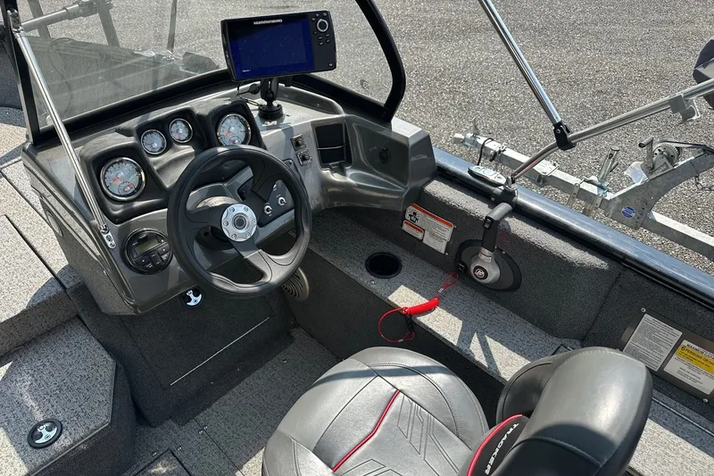 Slide: The Image of Interior of a 2021 Bass Tracker Pro 16 boat with steering wheel and control panel. - 32