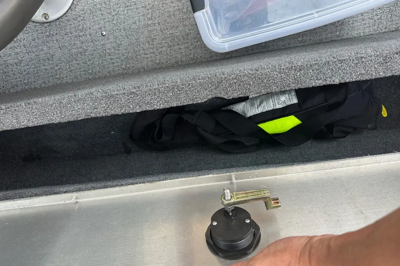Slide: The Image of Interior of a 2021 Bass Tracker Pro 16 boat showing storage compartment and safety equipment. - 27