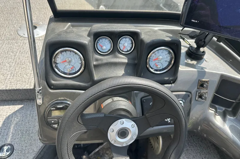 Slide: The Image of Dashboard of a 2021 Bass Tracker Pro 16 boat with steering wheel and gauges. - 24