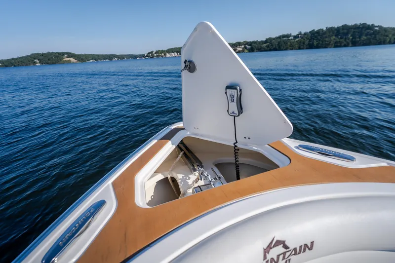 Slide: The Image of Fountain 39 DX 2026 boat anchor compartment open on calm lake. - 68