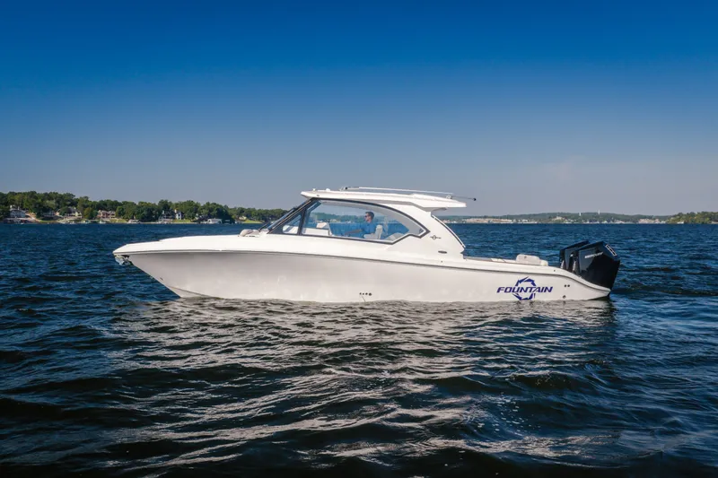 The Image of 2026 Fountain 39 DX boat cruising on a calm lake under a clear blue sky. - 2