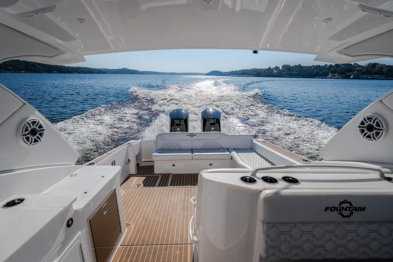 Slide: The Image of 2026 Fountain 39 DX boat cruising on a serene lake, showcasing luxury seating and powerful engines. - 59