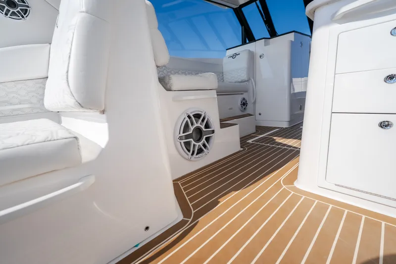 Slide: The Image of Interior of 2026 Fountain 39 DX boat with white seating and wood-patterned flooring. - 49