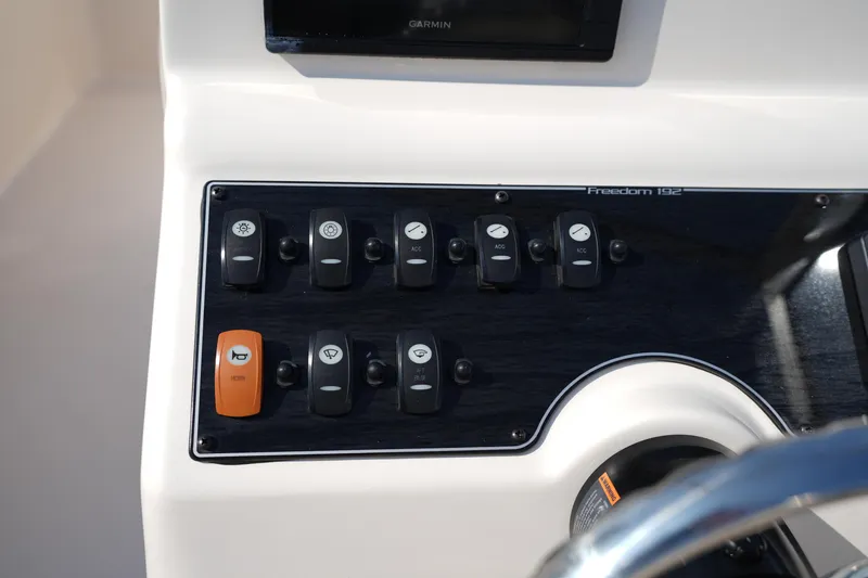 Slide: The Image of Control panel of 2018 Grady-White Freedom 192 boat with various switches and buttons. - 22