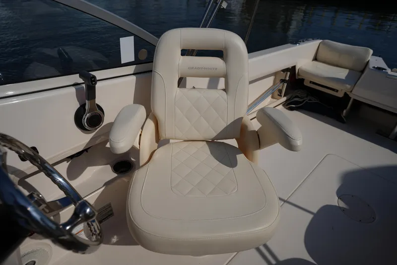 Slide: The Image of 2018 Grady-White Freedom 192 boat interior with beige captain's chair and steering wheel. - 20
