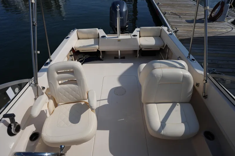 Slide: The Image of 2018 Grady-White Freedom 192 boat interior with white seating and docked at marina. - 28