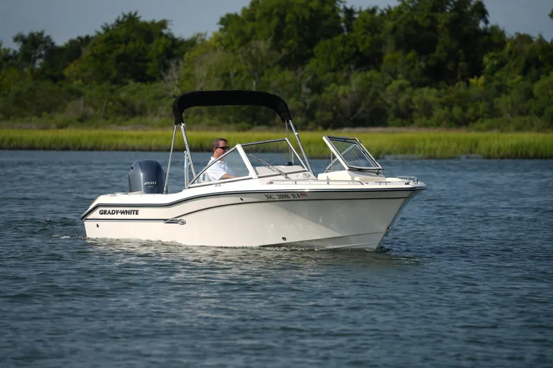 The Image of 2018 Grady-White Freedom 192 boat cruising on a calm lake with lush greenery. - 0