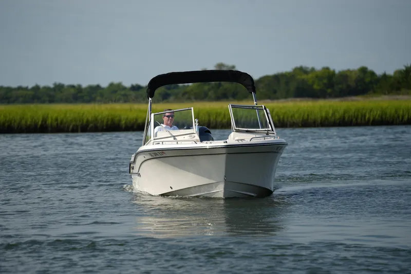 Slide: The Image of 2018 Grady-White Freedom 192 boat cruising on a calm river with lush greenery. - 13