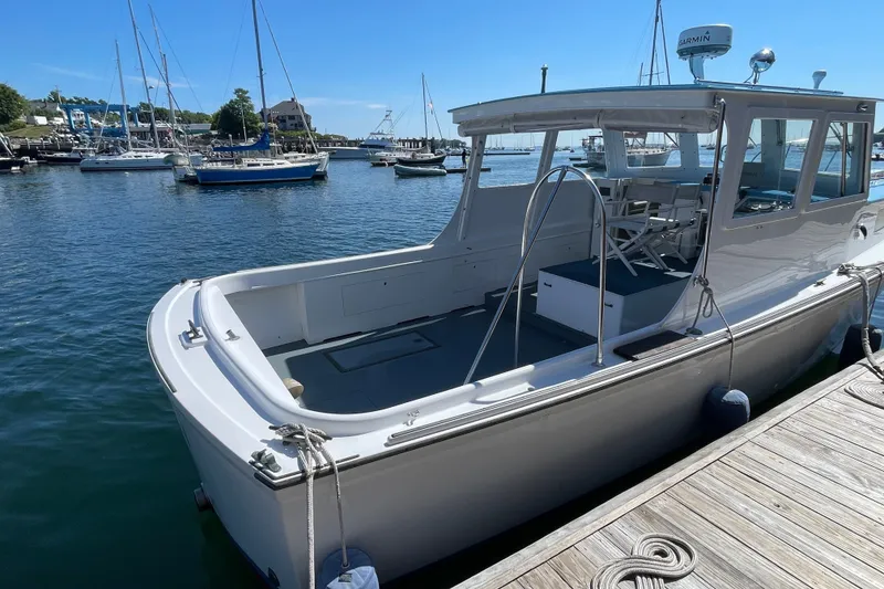 Slide: The Image of 1966 Webbers Cove 34 boat docked in a marina with clear blue skies. - 17