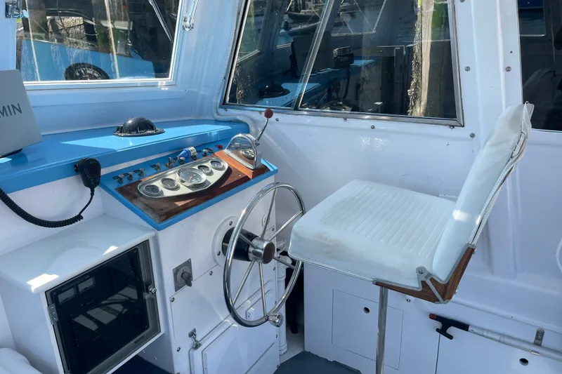 Slide: The Image of Interior of a 1966 Webbers Cove 34 boat, featuring helm controls and seating. - 36