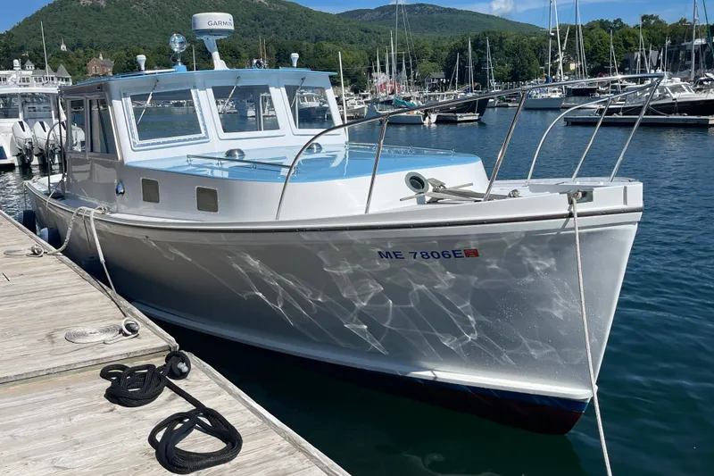 The Image of Classic 1966 Webbers Cove 34 boat docked in a scenic marina setting. - 0