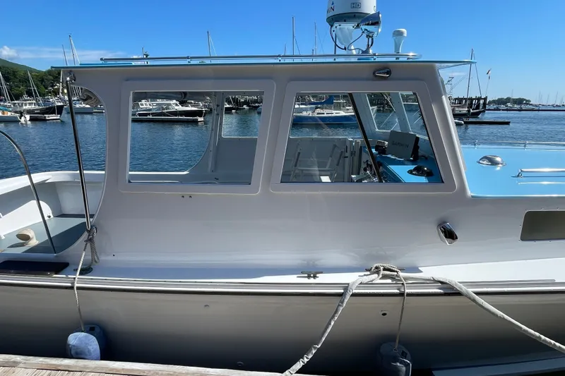 Slide: The Image of 1966 Webbers Cove 34 boat docked at marina, featuring sleek design and clear windows. - 15