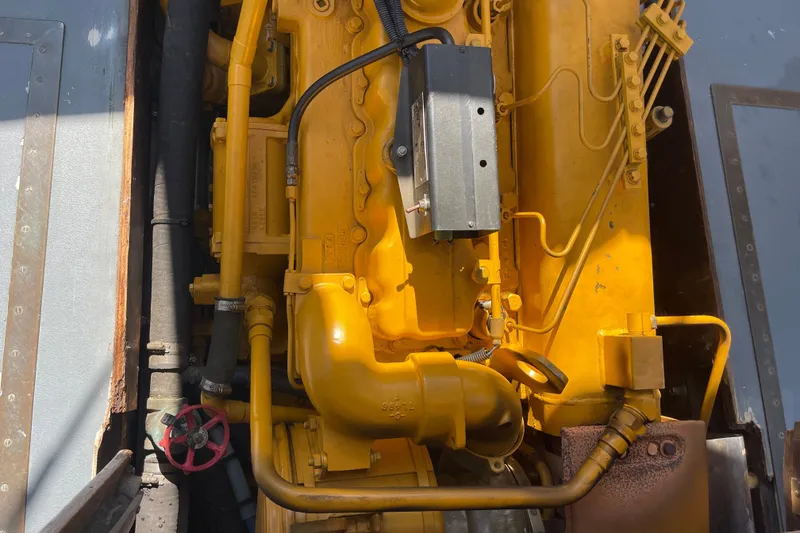 Slide: The Image of Yellow engine of a 1966 Webbers Cove 34 boat, showcasing detailed mechanical components. - 52