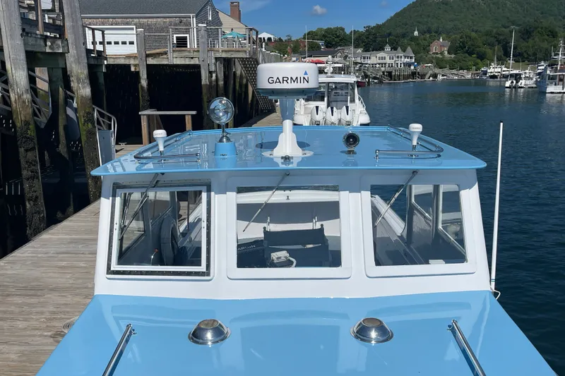 Slide: The Image of 1966 Webbers Cove 34 boat docked, featuring a blue and white exterior with Garmin equipment. - 21