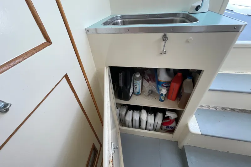 Slide: The Image of Storage cabinet with cleaning supplies and sink on a 1966 Webbers Cove 34 boat. - 46