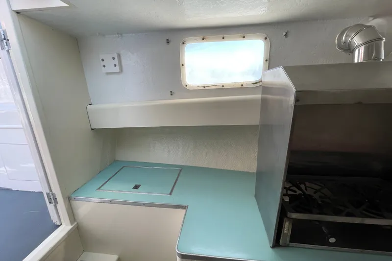 Slide: The Image of Interior of a 1966 Webbers Cove 34 boat, featuring a compact kitchen area. - 39