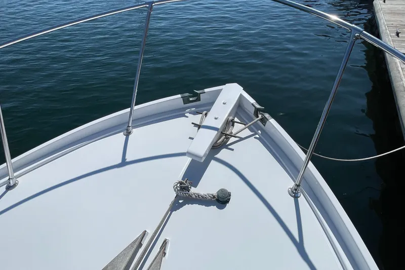 Slide: The Image of Bow of 1966 Webbers Cove 34 boat with anchor, docked on calm water. - 20