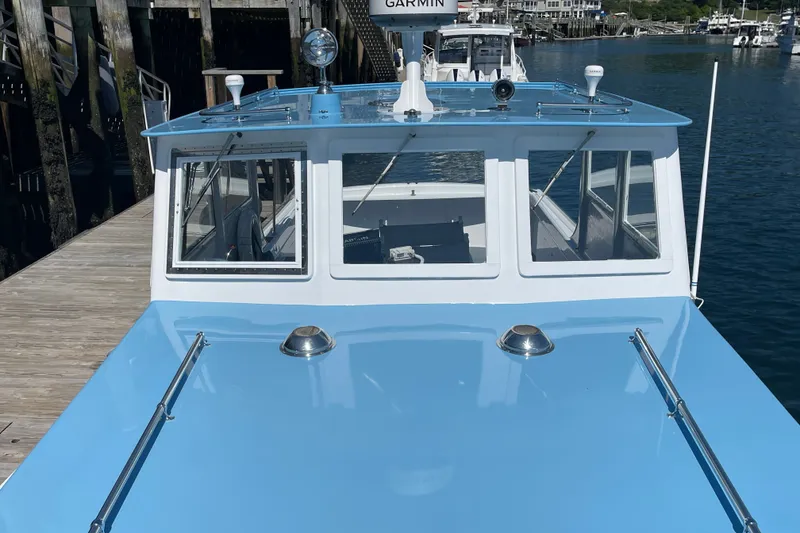 Slide: The Image of 1966 Webbers Cove 34 boat docked, featuring a blue and white exterior. - 22