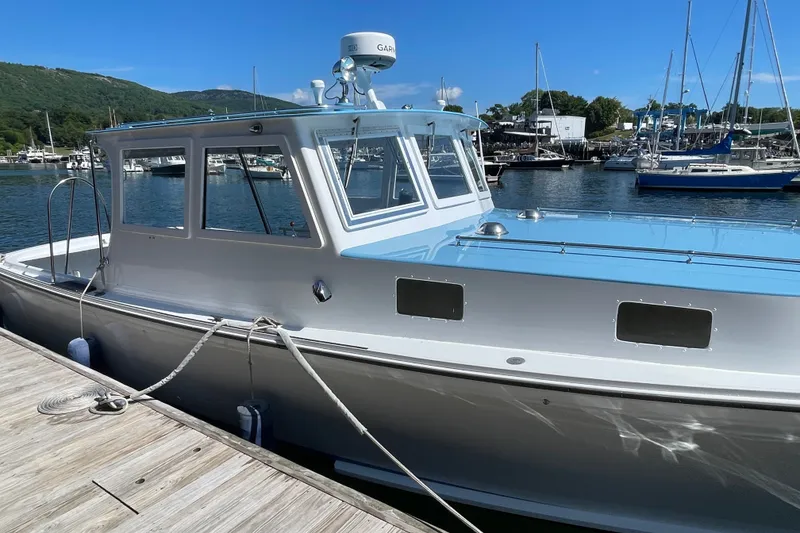 Slide: The Image of 1966 Webbers Cove 34 boat docked at marina, featuring classic design and blue accents. - 13