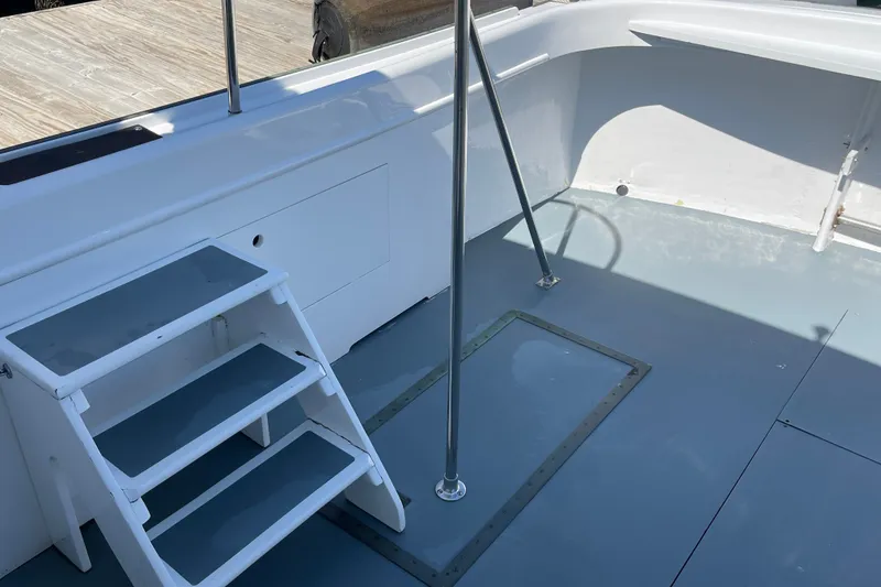 Slide: The Image of Interior of 1966 Webbers Cove 34 boat with steps and railing, featuring a clean deck. - 23