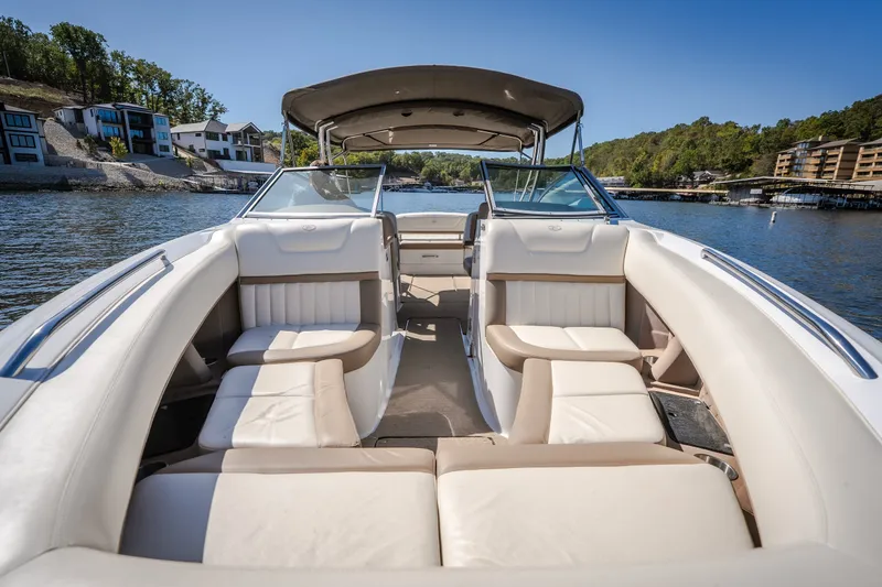 Slide: The Image of 2010 Cobalt 302 boat interior with beige seating, docked near waterfront homes. - 20