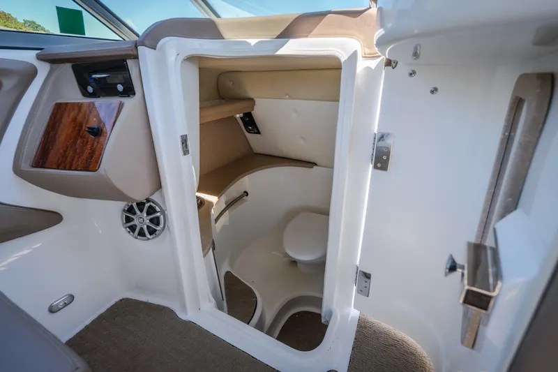 Slide: The Image of Interior of a 2010 Cobalt 302 boat featuring a compact marine toilet. - 12