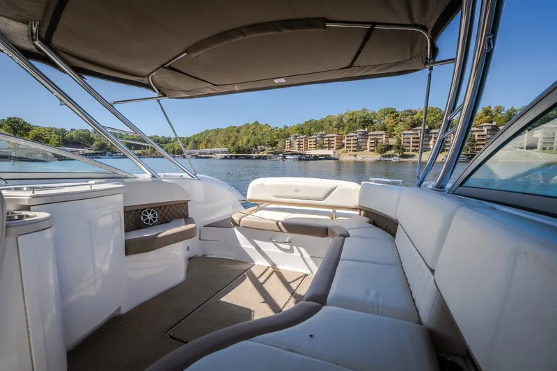 Slide: The Image of 2010 Cobalt 302 boat interior with spacious seating, overlooking a serene waterfront view. - 30