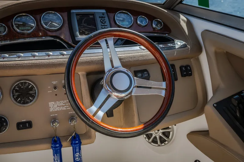 Slide: The Image of Steering wheel and dashboard of 2010 Cobalt 302 boat, featuring gauges and controls. - 41